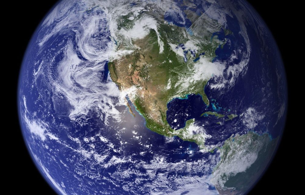地球在线高清卫星地图 品牌简介配图：编辑两人围坐在长桌前，桌面上摊开打印的卫星影像与标注笔，阳光从侧窗斜射进来，气氛安静专注